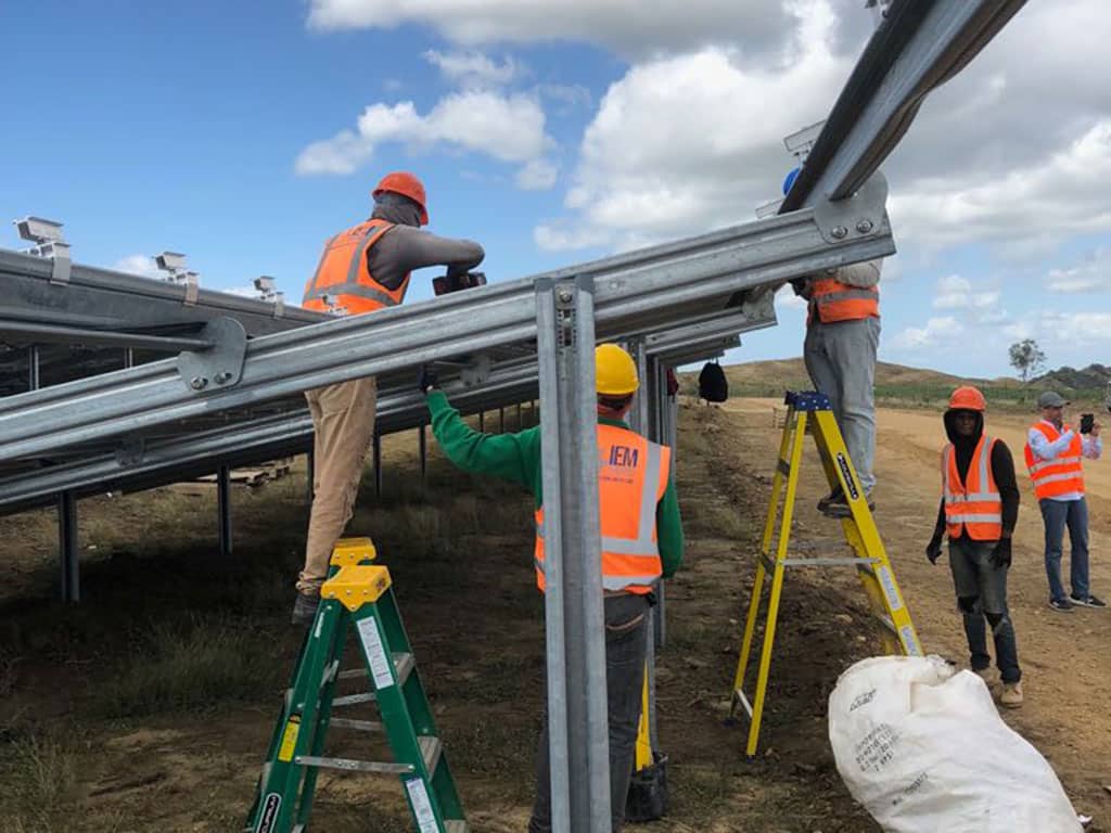 Workers building a solar farm framework